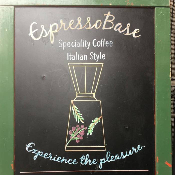 Espresso Base's hand-chalked sign reading 'Experience the pleasure'